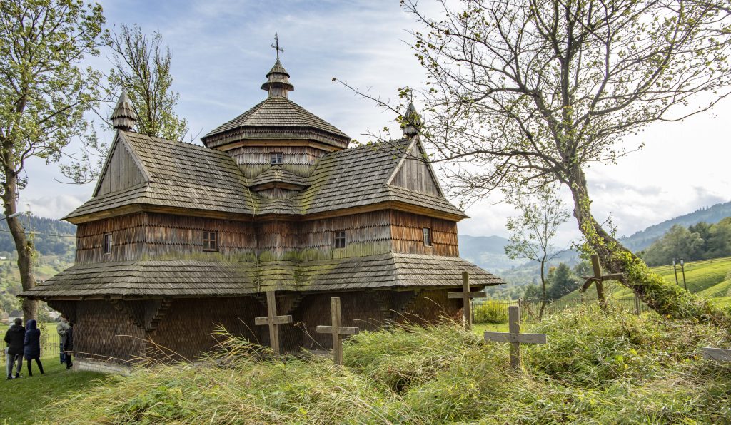 A wooden church with graves in the foreground